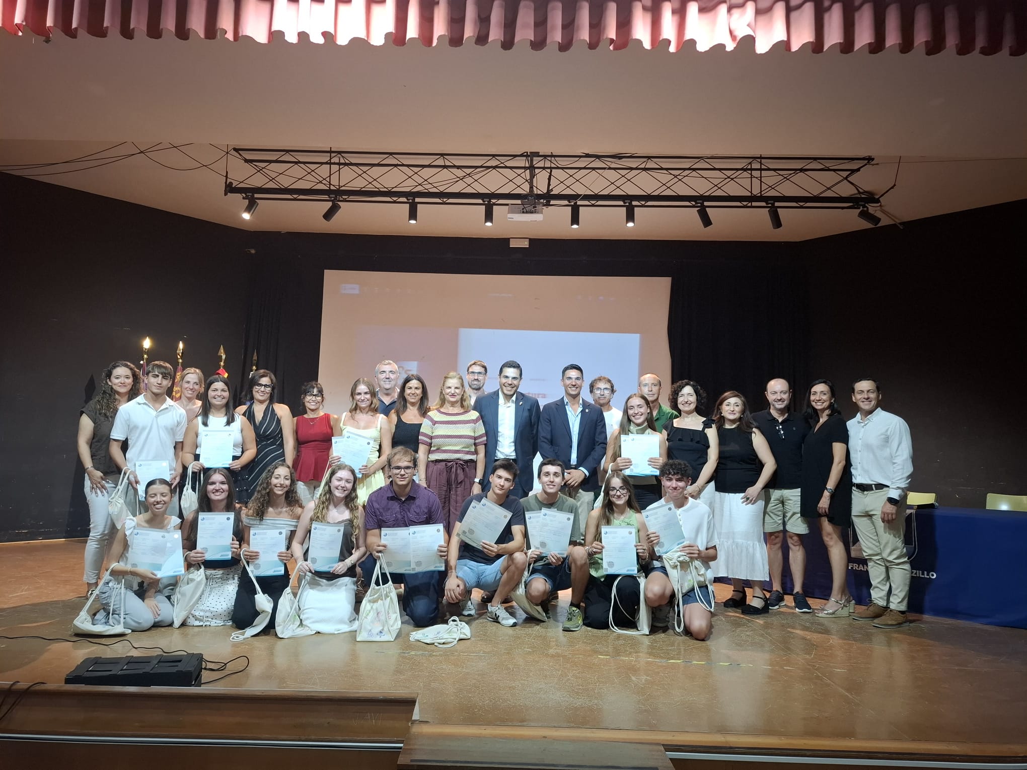 Alumnado de la 2ª promoción del Programa del Diploma junto al equipo docente y autoridades, mostrando sus diplomas de Bachillerato Internacional